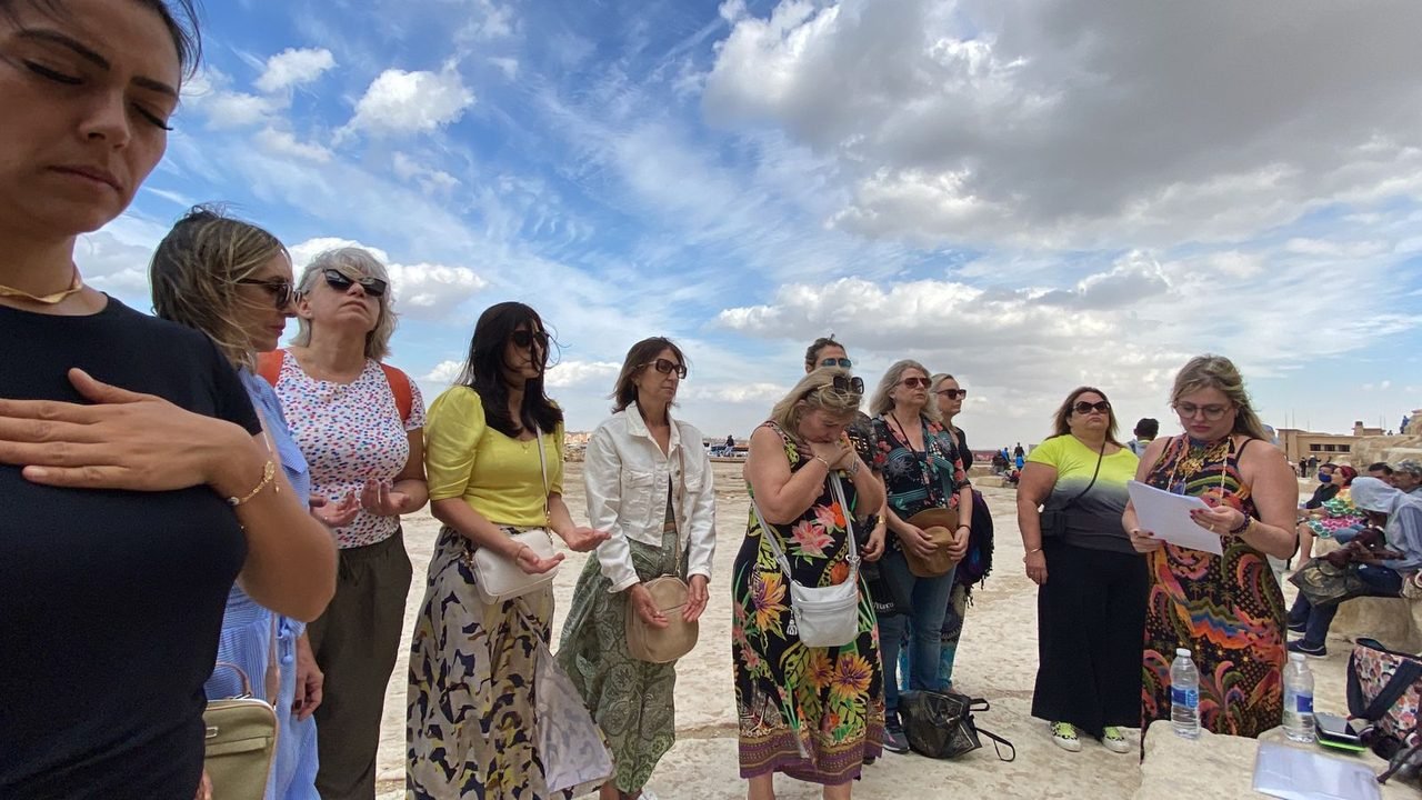Grupo de clientes da EGP Viagens reunido em oração em frente às Pirâmides de Gizé, no Egito