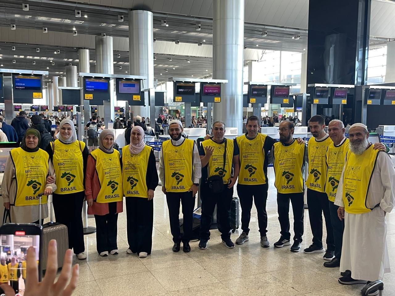 Grupo de clientes da EGP Viagens no aeroporto, uniformizados para roteiro religioso a Meca