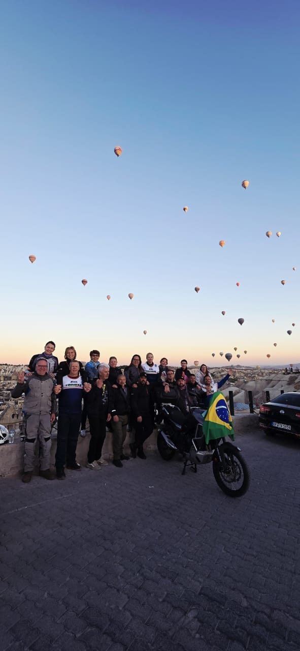 Grupo de clientes da EGP Viagens observando balões coloridos ao amanhecer na Capadócia, Turquia