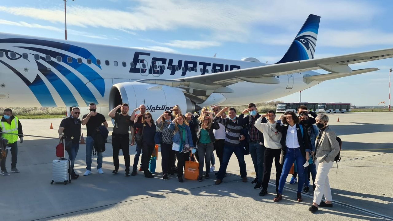 Grupo de clientes da EGP Viagens em frente a avião da EgyptAir antes do embarque