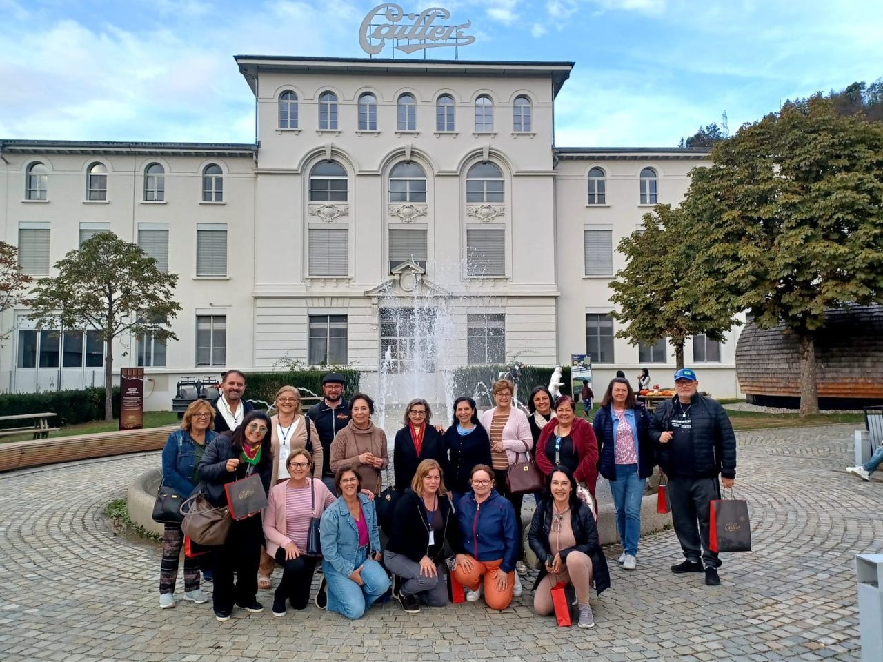 Grupo de clientes da EGP Viagens em frente a um palácio histórico com fonte, na Europa