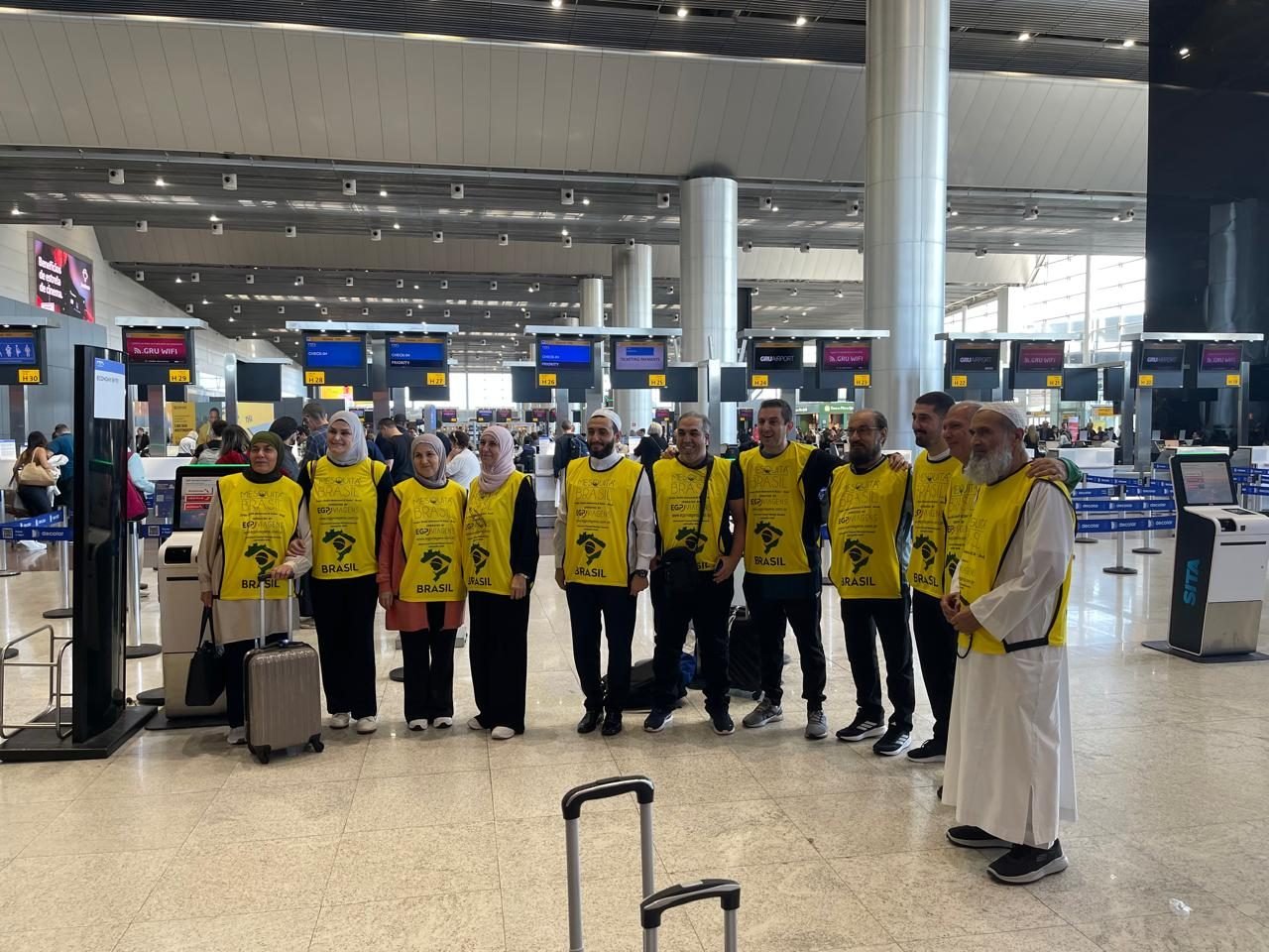 Grupo de clientes da EGP Viagens no check-in do aeroporto, uniformizados para roteiro religioso