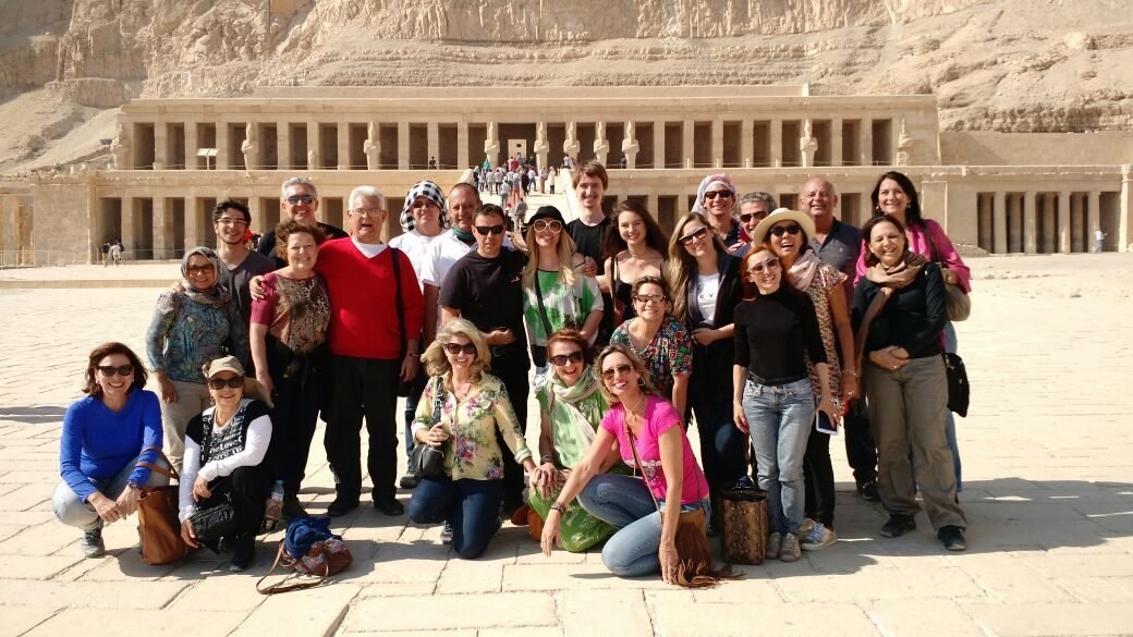 Grupo de clientes da EGP Viagens em um jardim florido durante roteiro turístico
