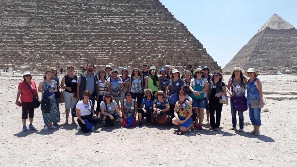 Grupo de clientes da EGP Viagens com vista das Pirâmides de Gizé ao fundo, no Egito