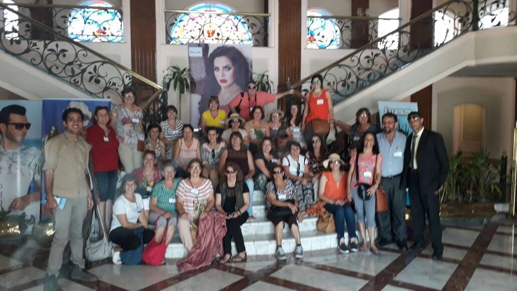 Grupo de clientes da EGP Viagens reunido em uma escadaria durante visita cultural