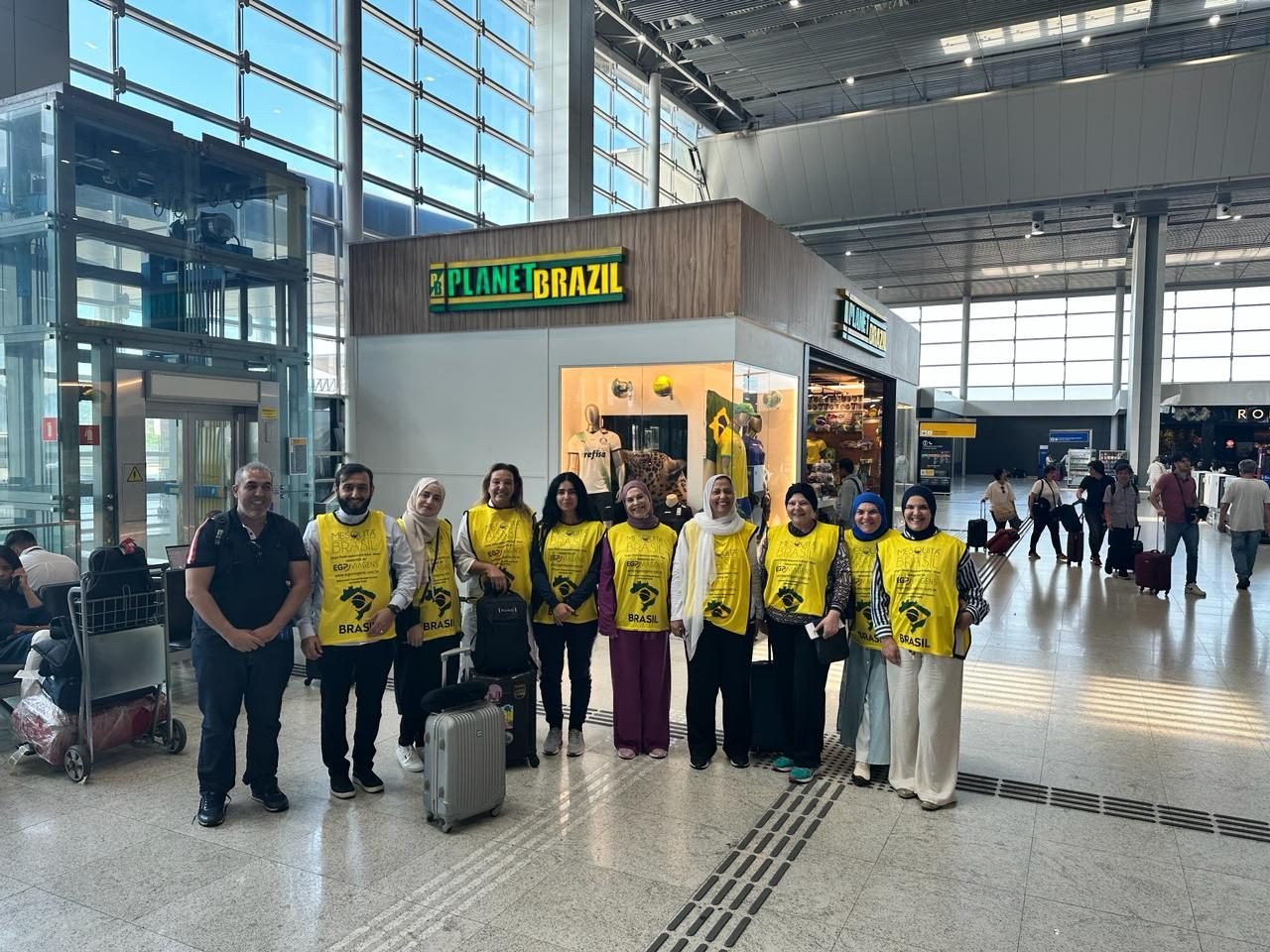 Grupo de clientes da EGP Viagens no check-in do aeroporto no Brasil, uniformizados para roteiro religioso