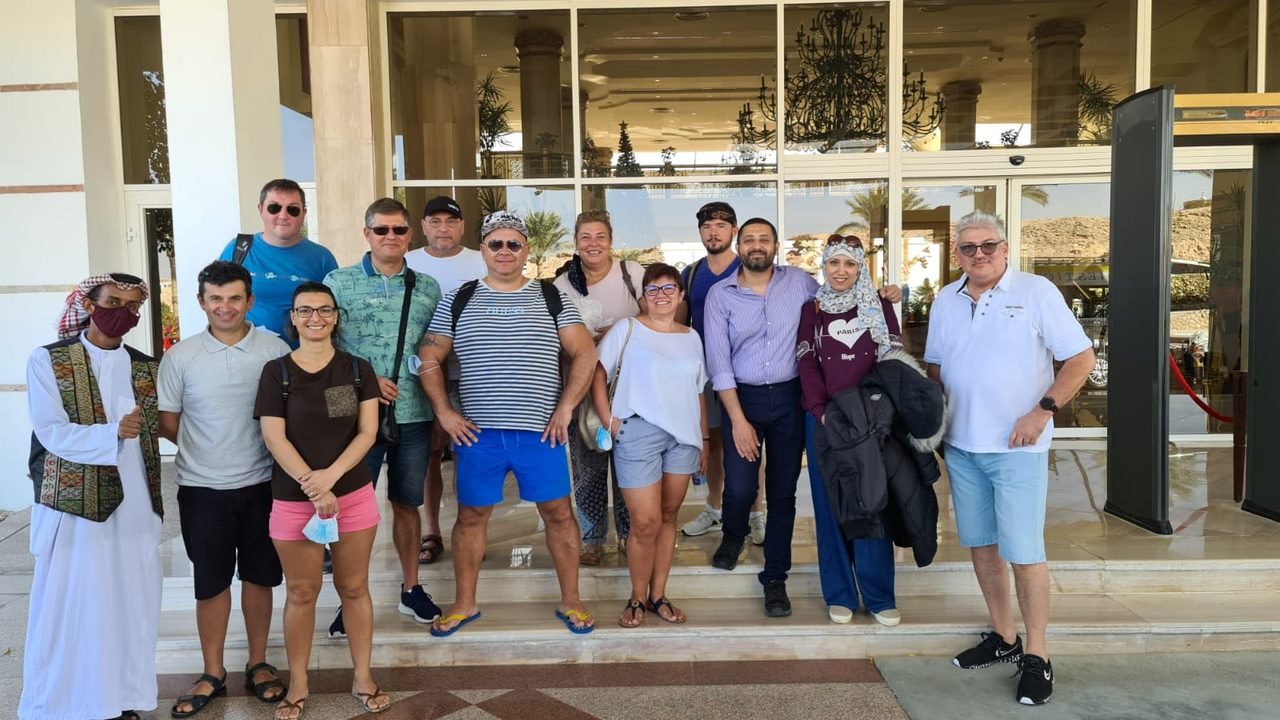 Pequeno grupo de clientes da EGP Viagens em frente a um estabelecimento local durante passeio