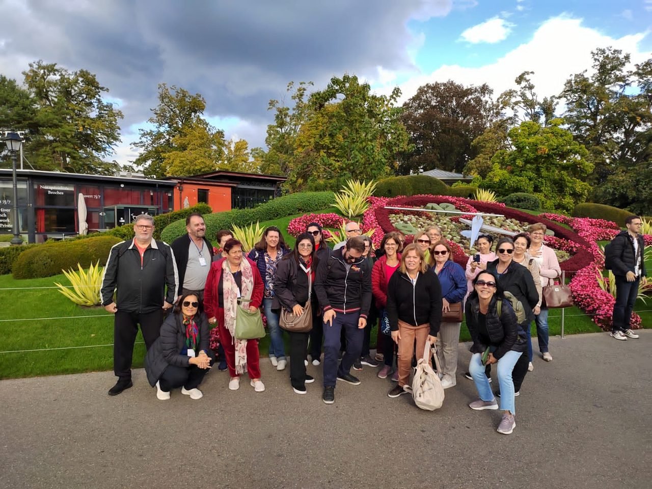 Grupo de clientes da EGP Viagens em um jardim florido durante passeio