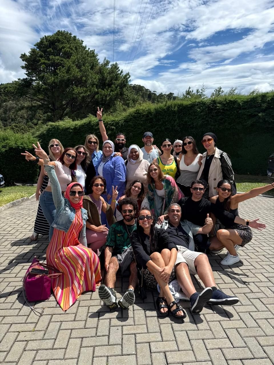 Grupo de clientes da EGP Viagens sorrindo em um jardim durante passeio