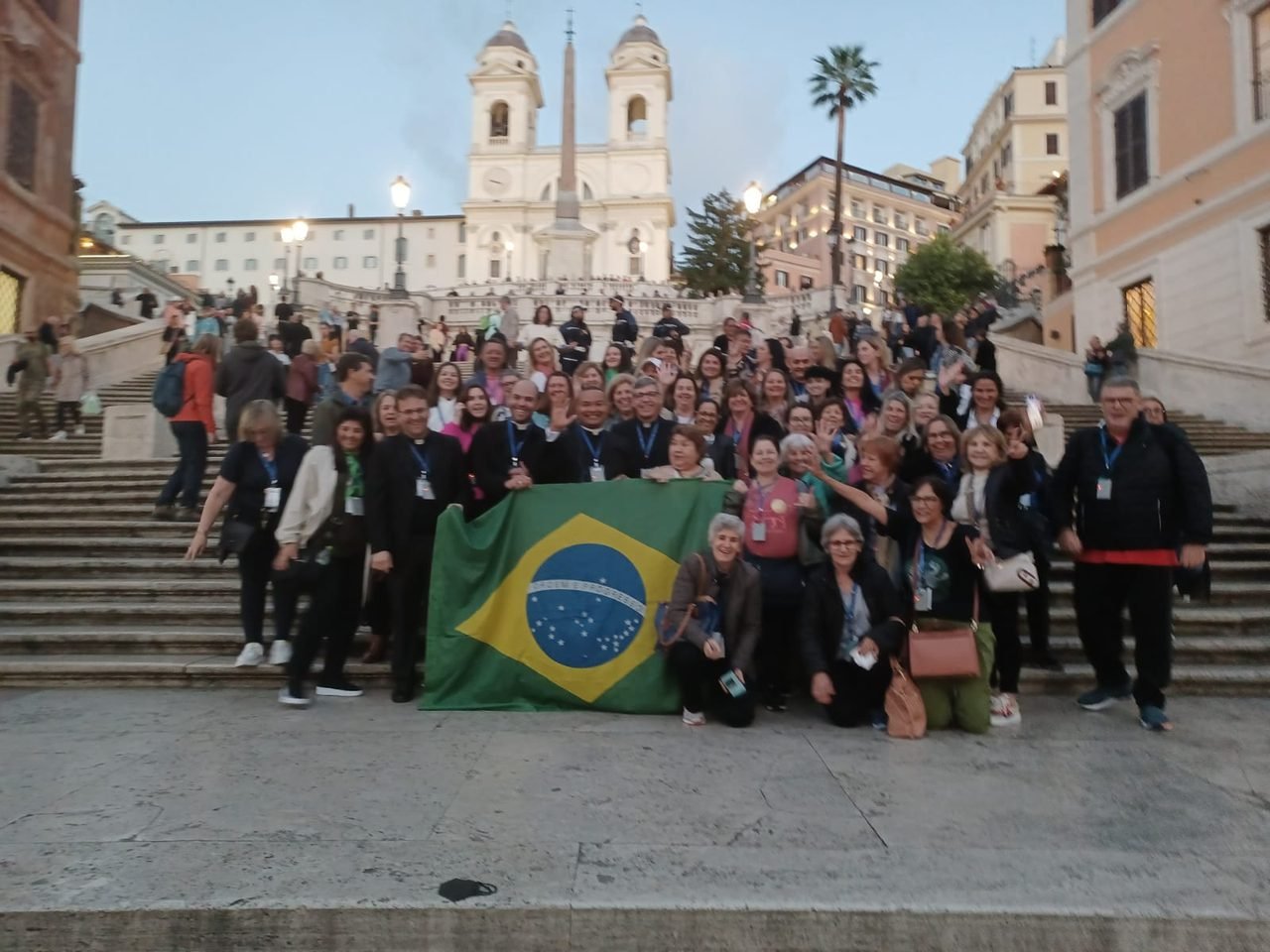 Grande grupo de clientes da EGP Viagens com a bandeira do Brasil na Piazza di Spagna, em Roma