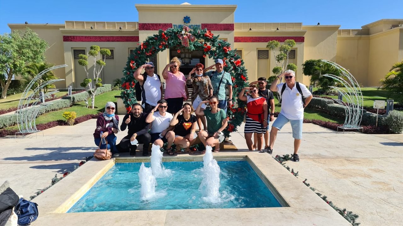 Grupo de clientes da EGP Viagens em pátio com decoração natalina durante viagem
